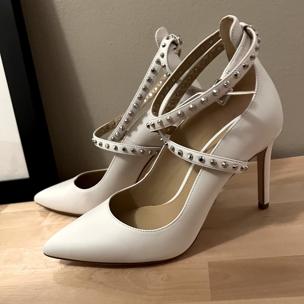 White pumps with ankle straps and spikes